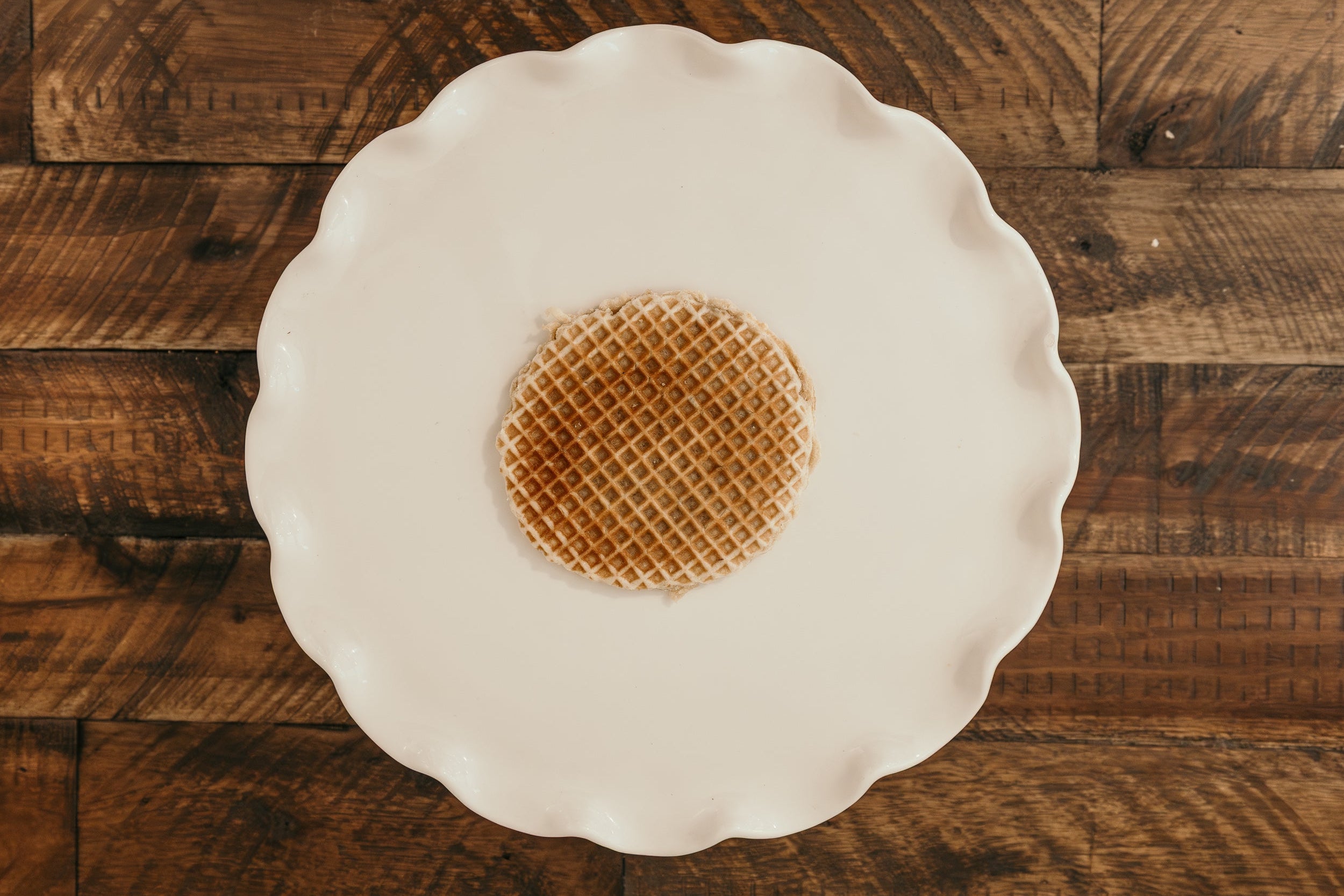 Waffle on a white plate against a wooden background