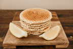 Stack of waffles on a wooden board with lemon wedges